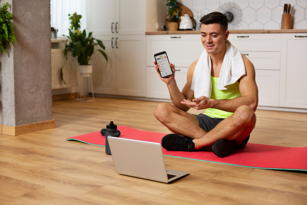 a man sitting on a yoga mat and holding a phone